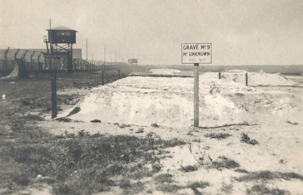 Signboard marking Grave No. 9, Belsen concentration camp, May 1945. Text reads: Grave No. 9, No. [Number] Unknown. Image © Durham Record Office (D/DLI 7/404/64)